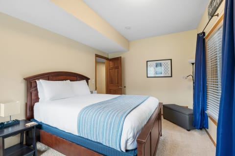 A well-decorated bedroom with a wooden bed, nightstand, and blue accents.
