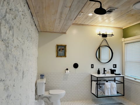 Stylish bathroom with exposed stone walls, modern fixtures, and natural light.