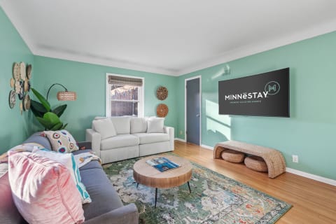 Stylish living room with mint green walls, a gray sofa, and decorative elements.