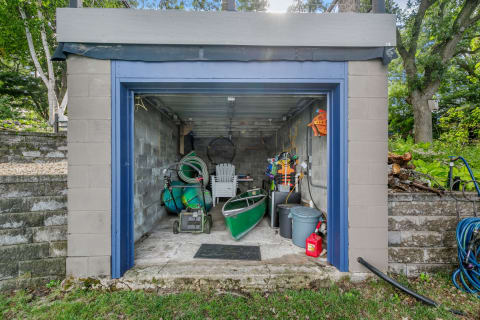 A cluttered garage showcasing a canoe, lawn mower, and outdoor equipment.