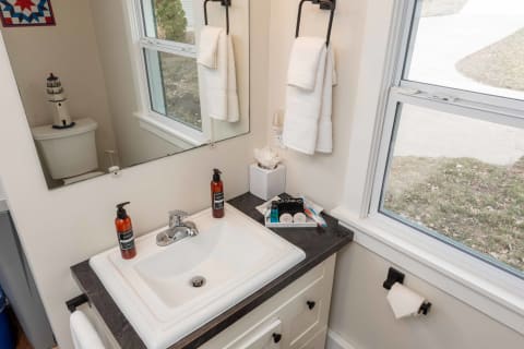 A bathroom sink with neatly arranged toiletries and a window view.