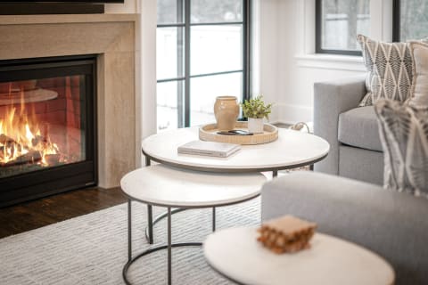 Living room featuring coffee tables, a fireplace, and a grey sofa.