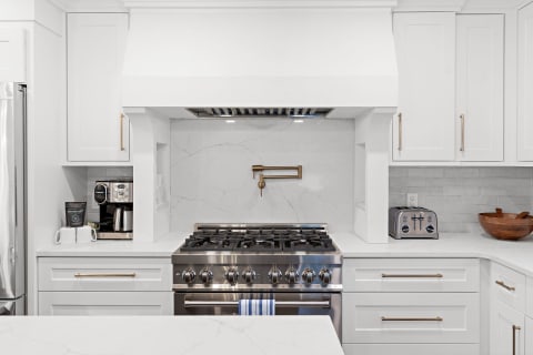 Modern kitchen with stainless-steel gas range and white cabinets