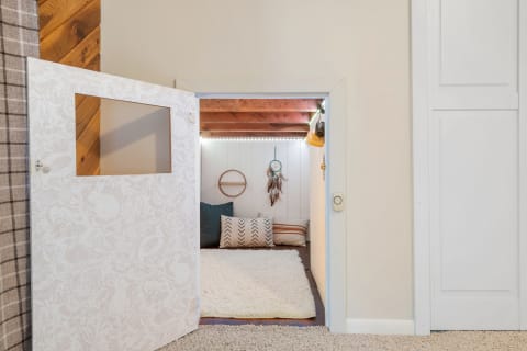 A cozy small room seen through a decorative door with an intricate pattern.
