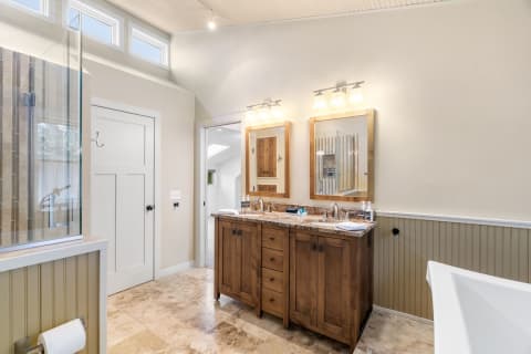 Interior of a stylish bathroom with a wooden vanity and glass shower.