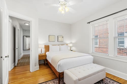 A cozy and modern bedroom featuring a neatly made bed and warm decor.