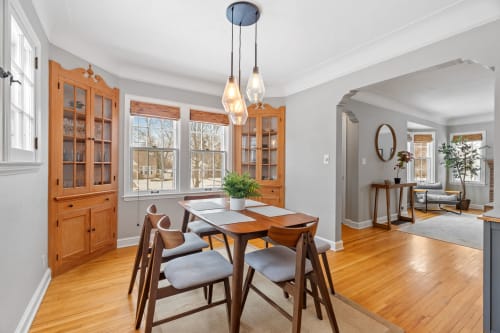 A cozy dining area featuring a wooden table and modern light fixture.