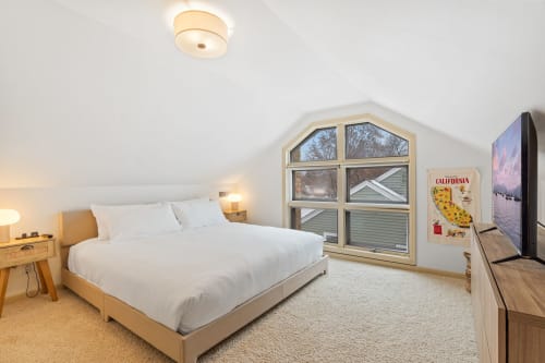 A cozy attic bedroom with modern decor and natural lighting.