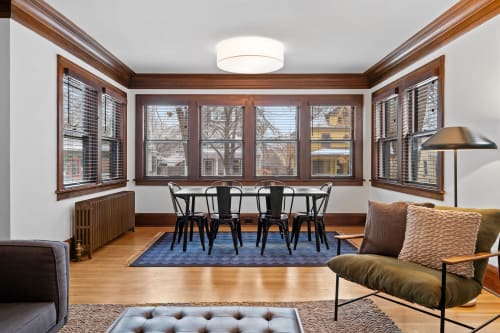 A stylish living area with a dining table and ample natural light.