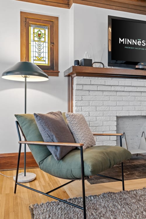 A cozy living room featuring modern decor and a stained glass window.