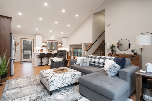 A bright and inviting modern living room featuring a cozy sectional sofa and stylish decor.