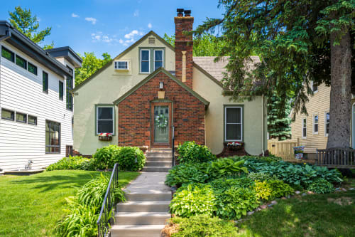 A charming house with lush greenery and a welcoming entrance.