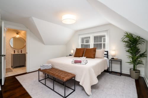 A cozy bedroom with modern decor and an attached bathroom.