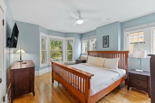 A serene bedroom with soft blue walls and natural light.