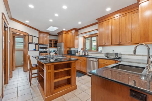 A modern kitchen with wooden cabinets and granite countertops.