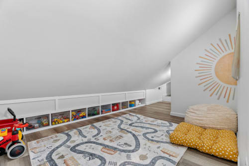 A cozy attic playroom filled with toys and inviting seating.