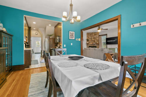 Cozy dining area with modern kitchen and vibrant turquoise walls.