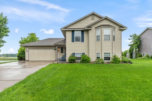 A lovely two-story home with a manicured lawn and inviting front steps.