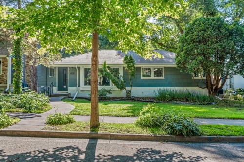 A cozy single-story home surrounded by lush greenery in a peaceful neighborhood.