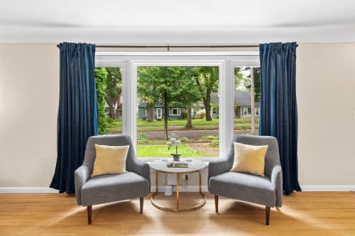 A cozy sitting area with gray armchairs and a view of the outdoors.