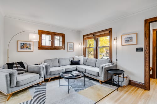A modern and welcoming living room with a stylish gray sectional couch and abundant natural light.