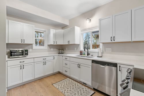 A modern, bright kitchen with white cabinetry and a sleek design.
