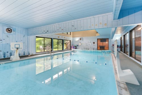 An inviting indoor swimming pool with a playful underwater theme.