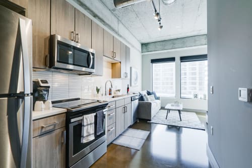 A stylish modern kitchen seamlessly flows into a cozy living area, showcasing contemporary design.