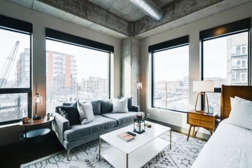 A stylish apartment with modern decor and expansive windows showcasing urban views.
