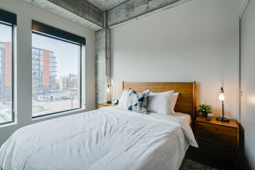 A modern bedroom with large windows and minimalistic decor.