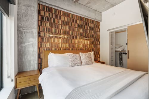 A cozy bedroom with a literary-themed wallpaper and modern design elements.