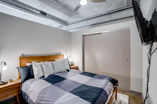 A modern and inviting bedroom with a cozy bed and industrial elements.