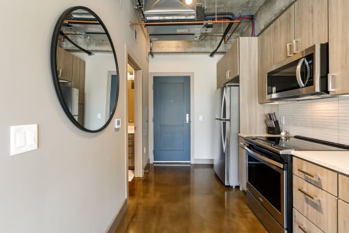 A sleek and modern kitchen featuring wooden cabinets and stainless steel appliances.