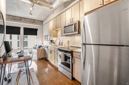 A modern kitchen and living area in a compact apartment, featuring stylish appliances and decor.