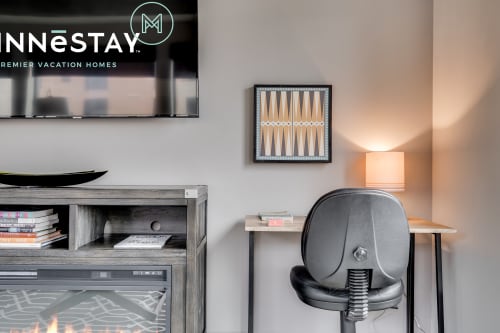 A cozy and modern living space featuring a TV, books, and a stylish desk area.