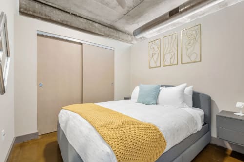 A chic, modern bedroom featuring a cozy bed and stylish decor.