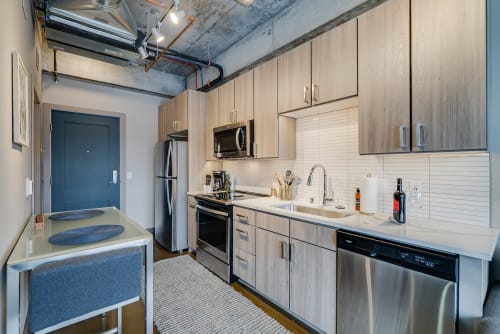 A modern kitchen featuring light wood cabinets and sleek appliances.