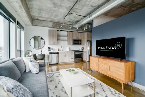 A stylish urban living room featuring modern decor and an open kitchen.