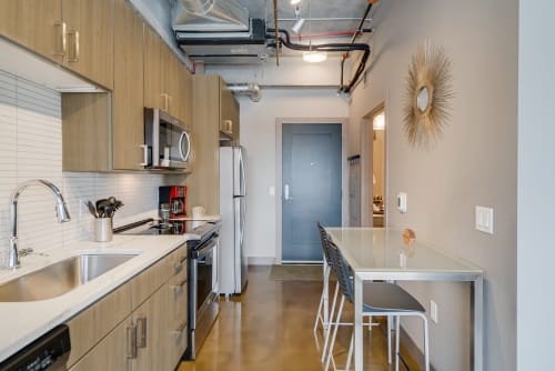 A sleek and modern kitchen with a dining area in an apartment.