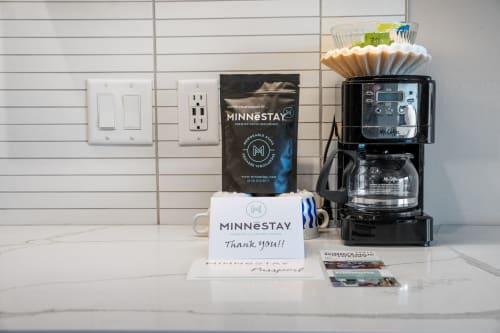A welcoming coffee station featuring items from MINNESTAY, complete with a coffee maker, complimentary coffee, and a thank you note.