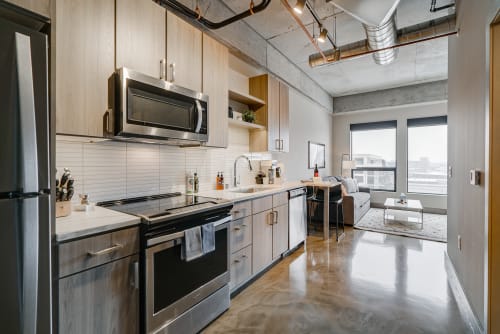 A modern kitchen and living area featuring sleek finishes and natural light.