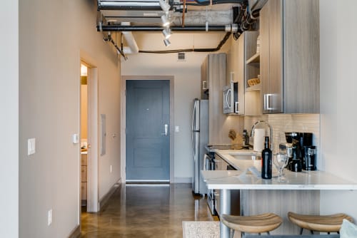 A modern kitchen area featuring sleek cabinetry and stainless steel appliances.