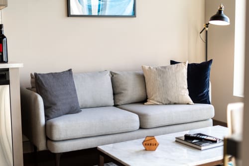 A modern living room with a light gray couch and stylish decor elements.