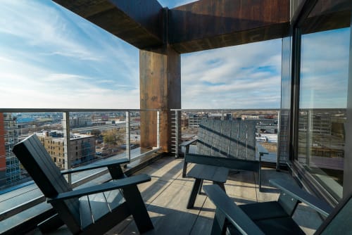 A modern balcony featuring Adirondack chairs with a stunning city view.