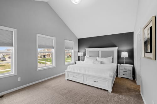 A serene bedroom with modern decor and ample natural light.