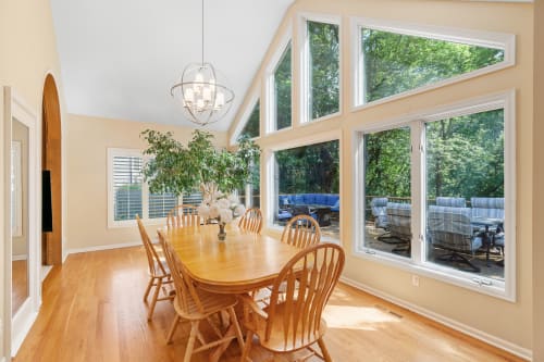 A bright dining room with large windows and a view of nature.