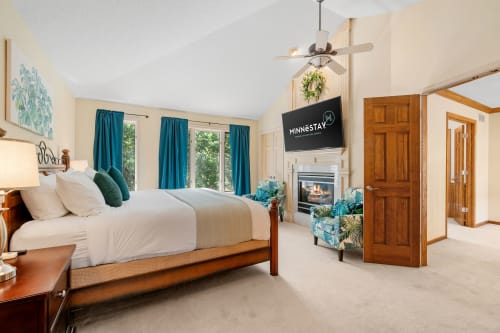 A serene bedroom with modern amenities and tropical decor.