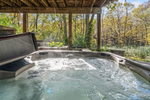 A soothing outdoor hot tub surrounded by autumn foliage.