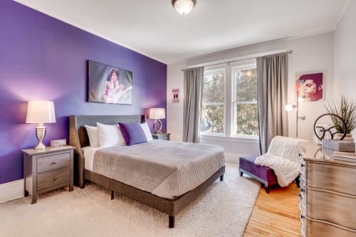 A vibrant bedroom with purple accents and cozy furnishings.