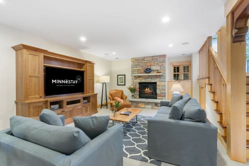 A warm and inviting living room featuring cozy furnishings and a stone fireplace.